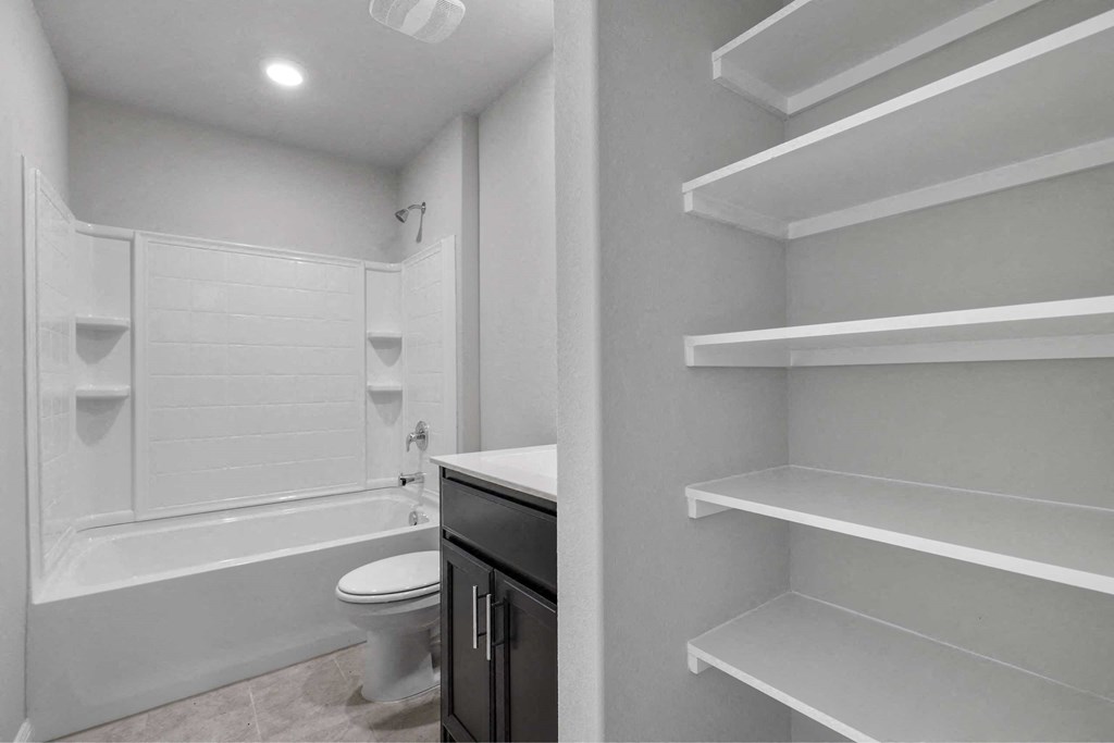 a renovated bathroom with white cabinets and a toilet and a shower