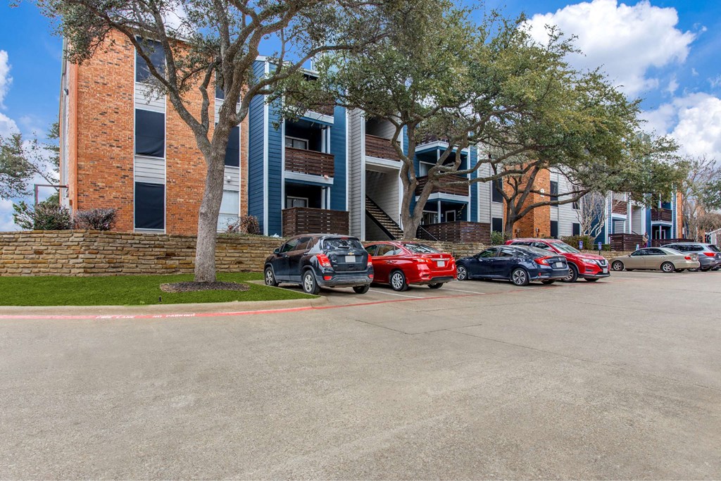 a row of cars parked in front of an apartment building