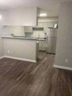an empty kitchen with a stainless steel refrigerator