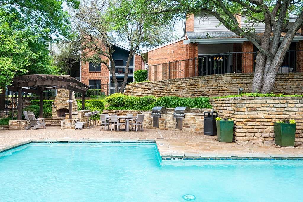 a swimming pool with a patio with chairs and a