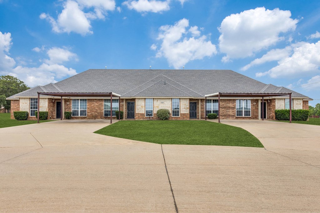 a large brick house with a lawn in front of it