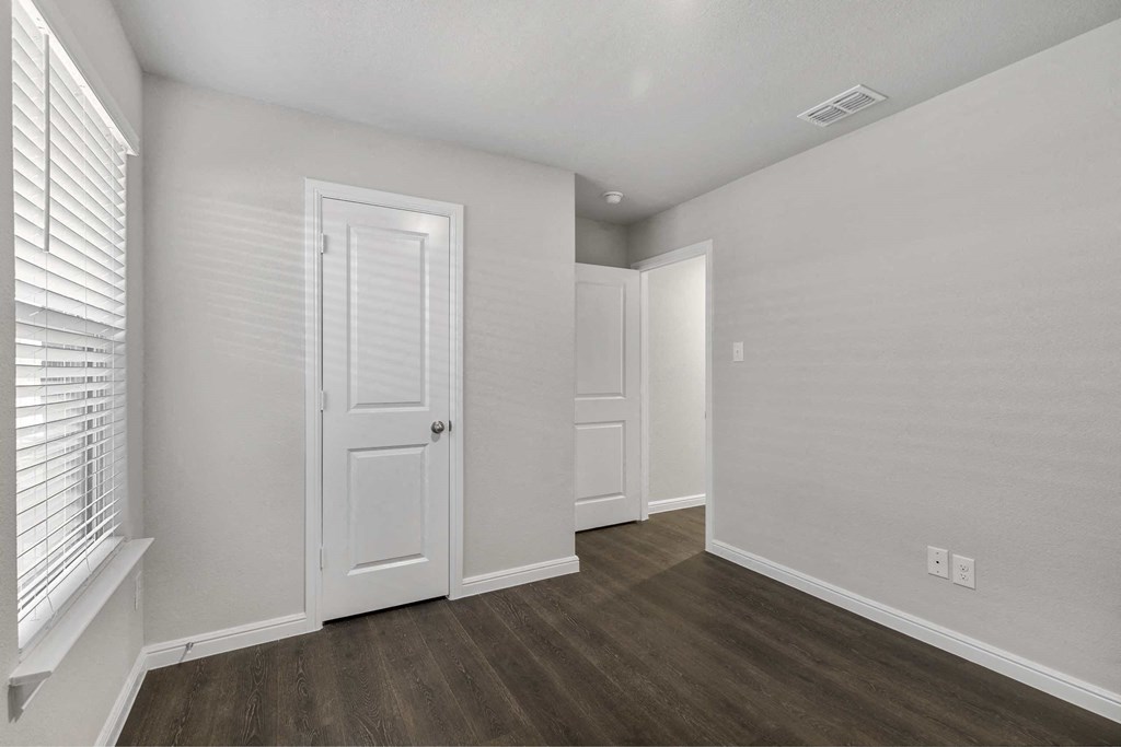 a renovated living room with white walls and wood floors