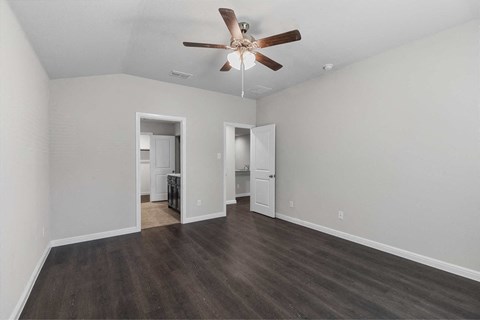 a living room with white walls and a ceiling fan