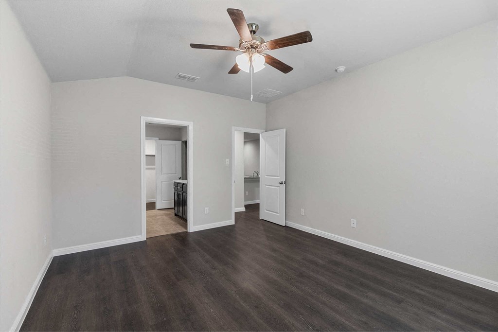 a living room with white walls and a ceiling fan