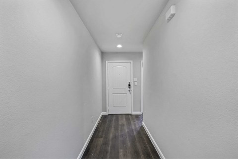 a white room with a white door and wood floors