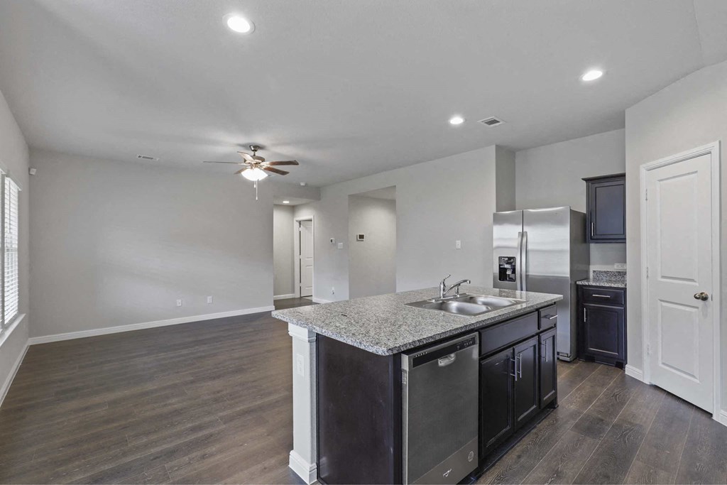 a kitchen with an island and a ceiling fan