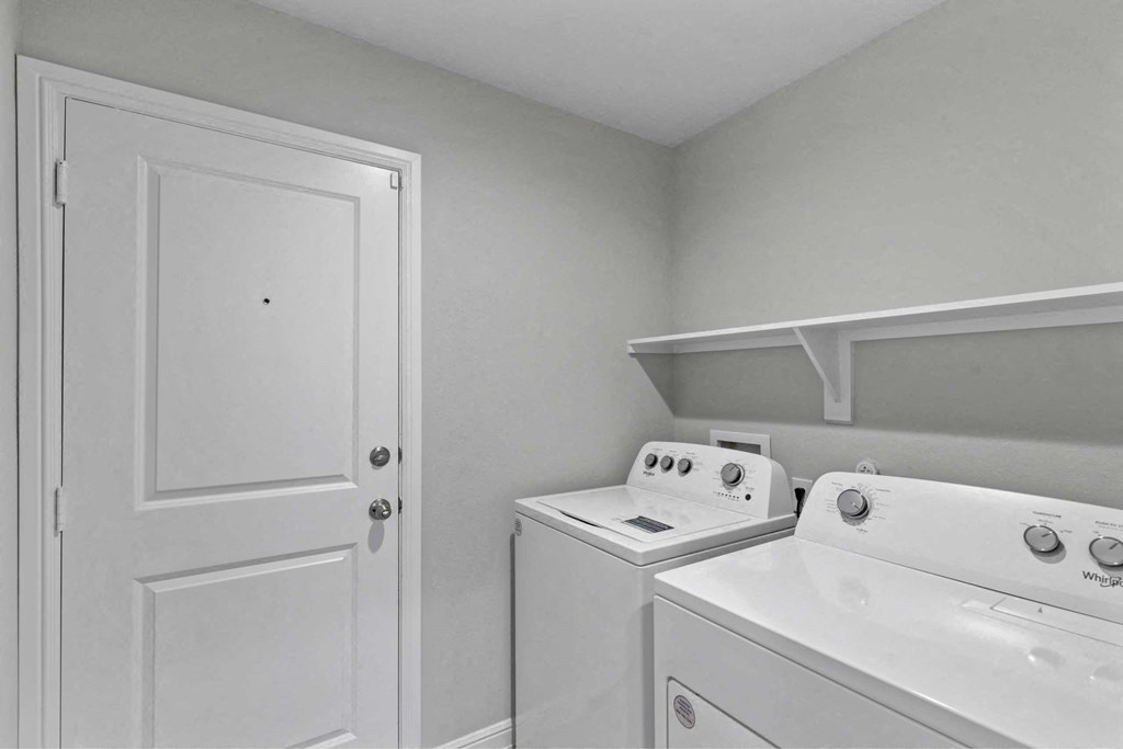 a white washer and dryer in a laundry room with a white door