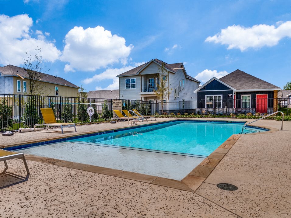 a swimming pool with houses in the background