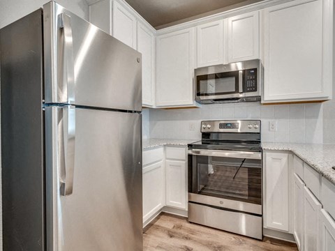 a kitchen with stainless steel appliances and white cabinets