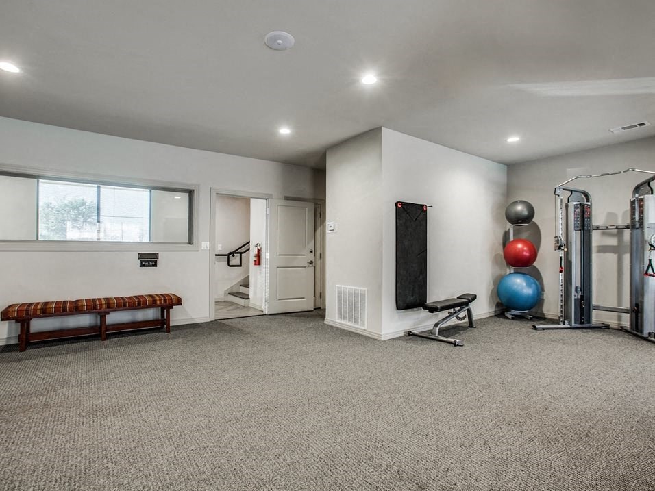 the gym has plenty of cardio equipment and a large window
