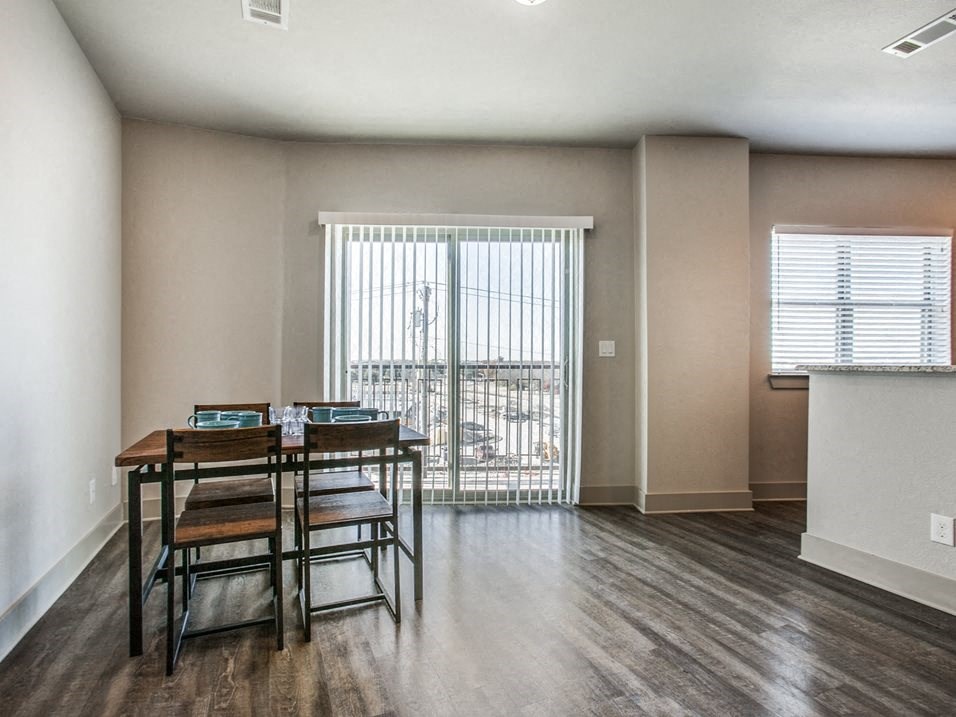 a dining room with a table and chairs and a window