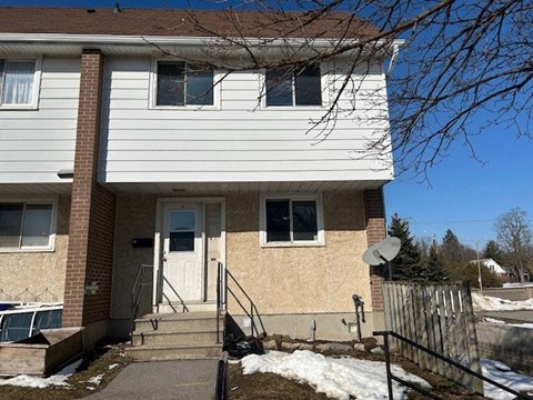a white and brown house with stairs