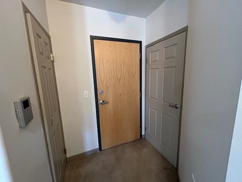 A hallway with a wooden door in the middle.
