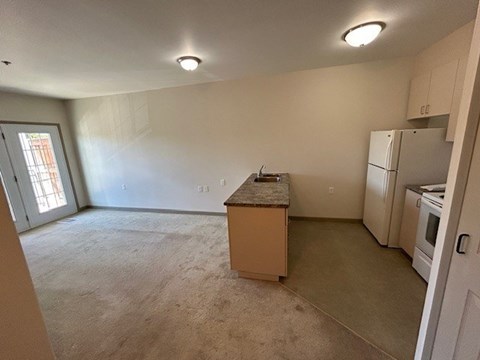 A kitchen area with a refrigerator, oven, and a countertop.