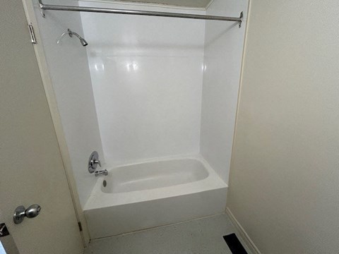 a small bathroom with a shower and a white tub