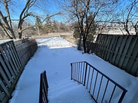 a snow covered yard with a fence and a gate