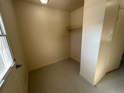 a small room with a closet and a window