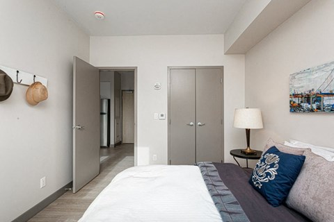A bedroom with a bed, a lamp, and a painting on the wall.