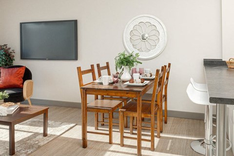 A dining room with a wooden table and chairs.