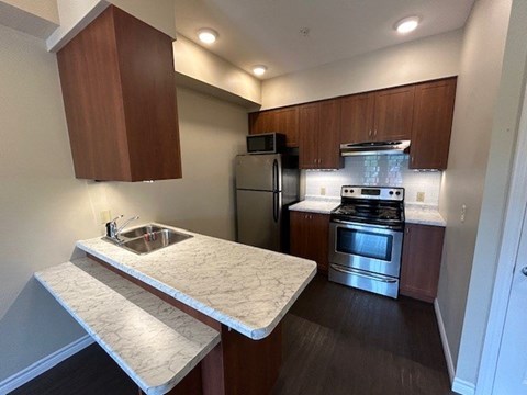 A kitchen with a stove top oven and a sink.
