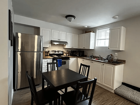 A kitchen with a table and chairs.