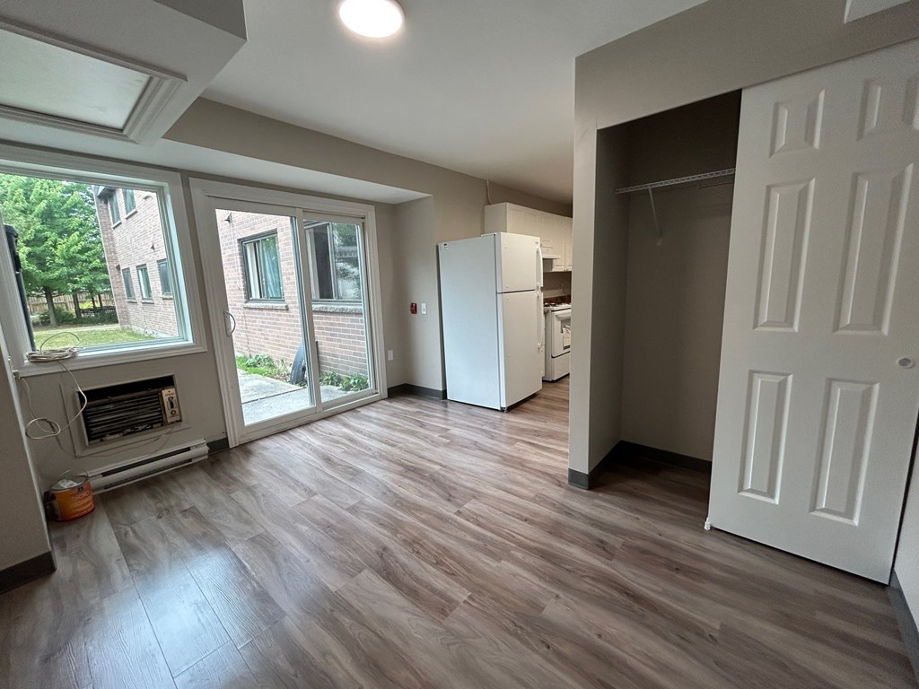 A kitchen with a white fridge and a white door.