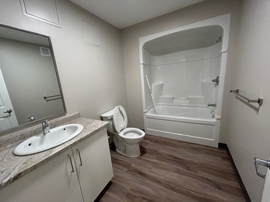 A bathroom with a sink, toilet, and bathtub.