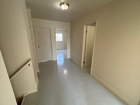 an empty hallway with doors and a light on the ceiling