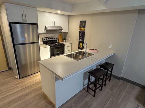 A kitchen with a stainless steel refrigerator and a white countertop.