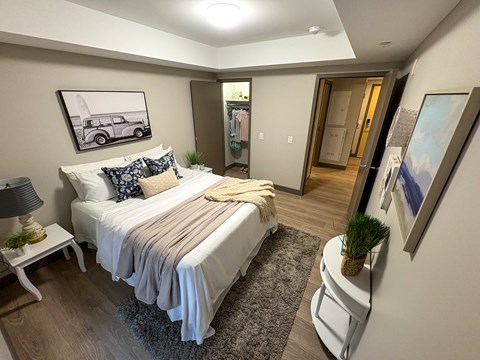 A bedroom with a bed, nightstand, and lamp.