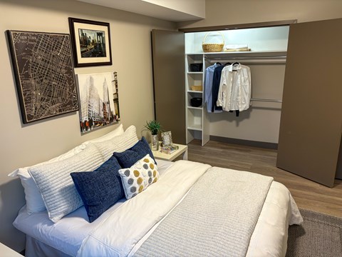 A bedroom with a white bed and a city map on the wall.
