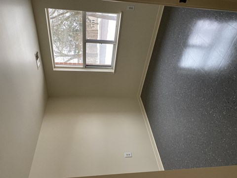 A room with a window and a wall.