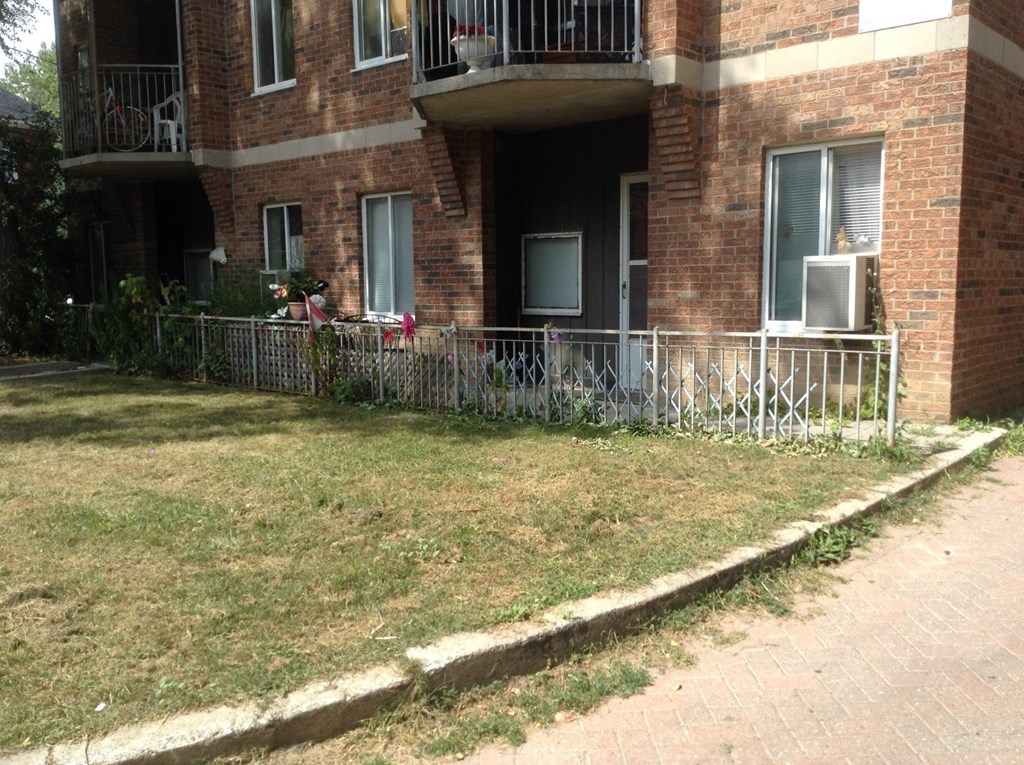 A brick building with a balcony and a metal railing.