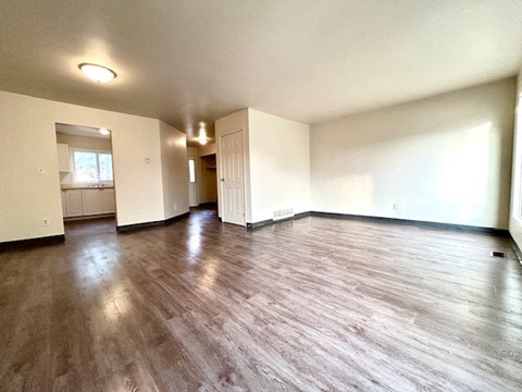 an empty living room with a hard wood floor