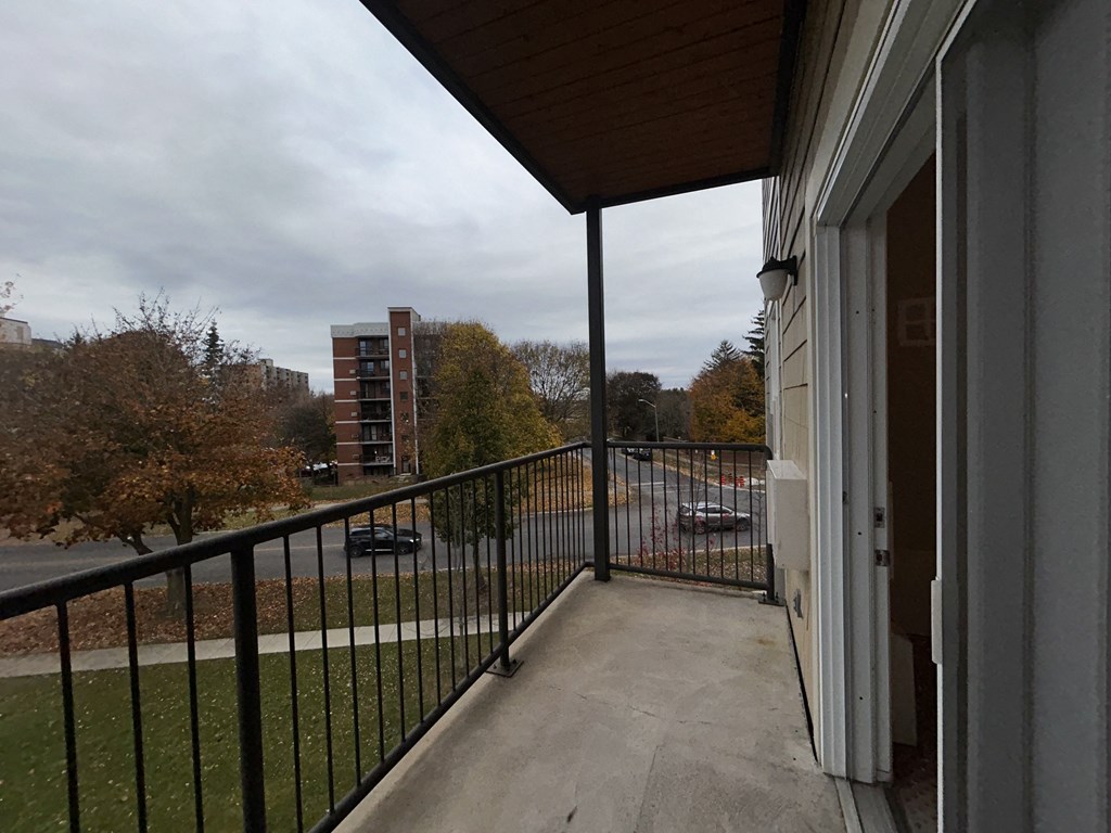 a balcony with a view of a city street and a parking lot