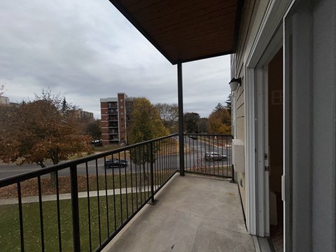a balcony with a view of a city street and a parking lot