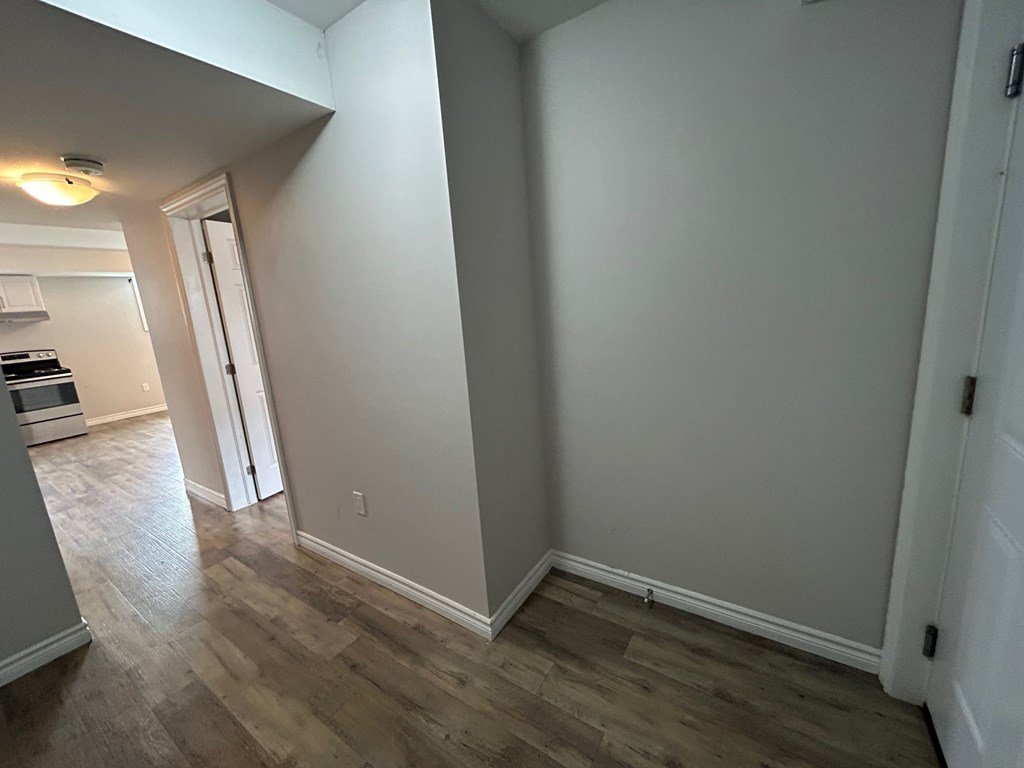 A room with wood flooring and white walls.