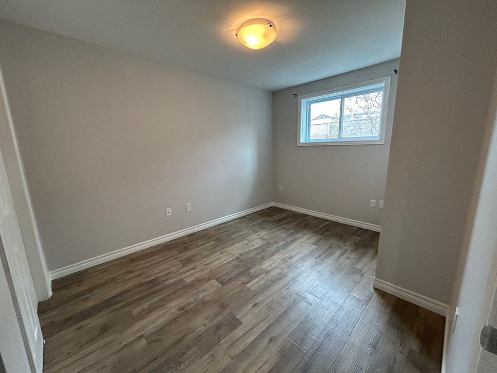 A room with wooden flooring and a window.