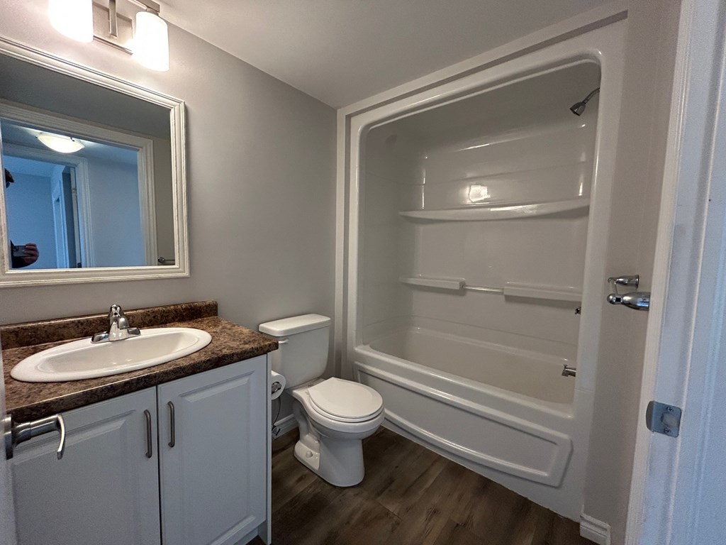 A bathroom with a toilet, sink, and bathtub.