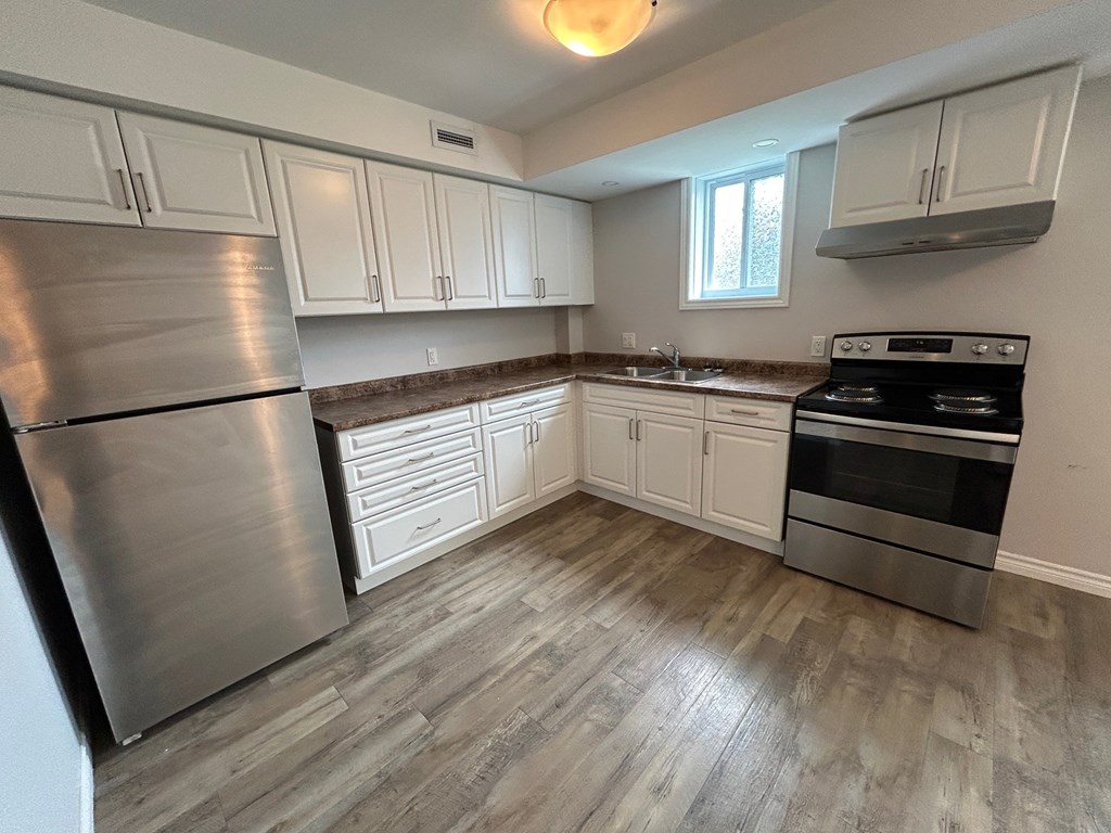 A kitchen with a stainless steel refrigerator and a stainless steel oven.