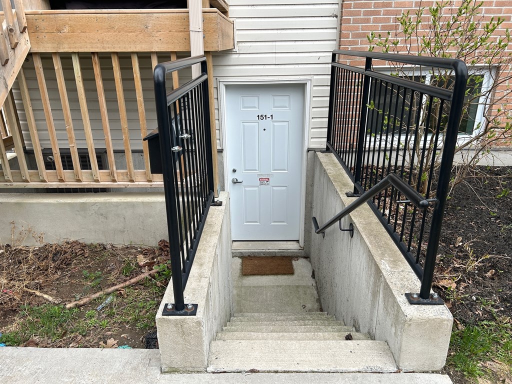 A white door with a black railing on the left and right.