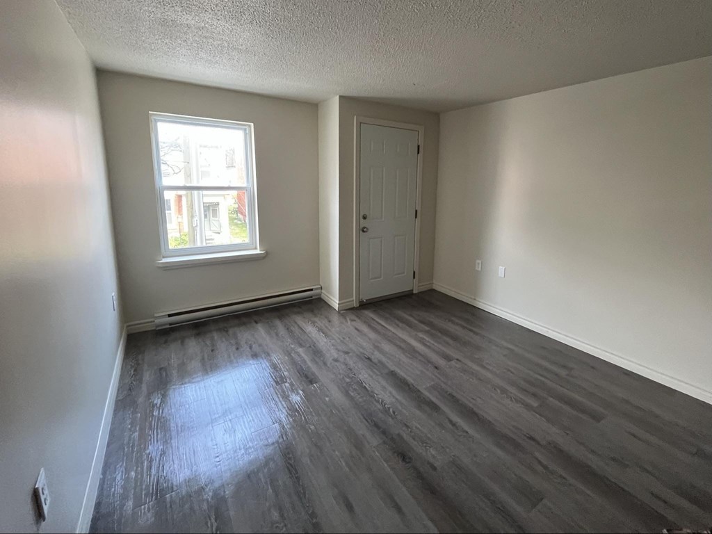 A room with a grey floor and a white door.