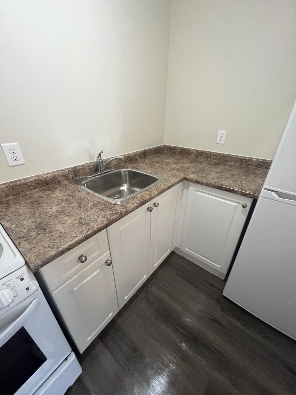 A kitchen with a granite countertop and white appliances.