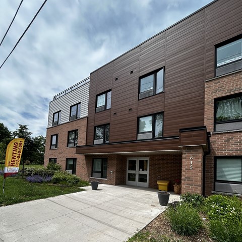 A building with a sign that says "RENTING" in front of it.