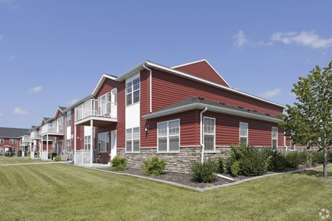 A red house with white trim and a stone foundation.