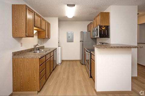 A kitchen with wooden cabinets and a granite counter top.