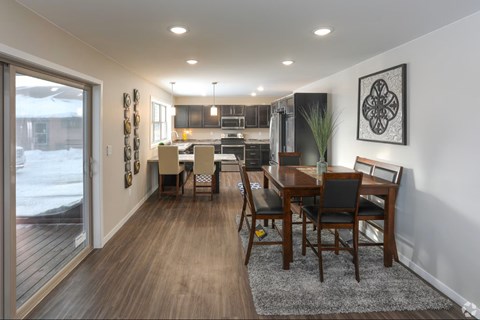 A modern dining room with a wooden table and chairs.