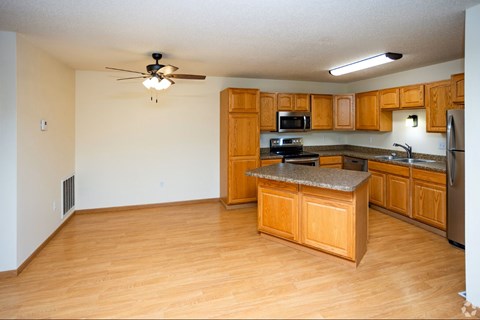 A kitchen with wooden cabinets and a granite countertop.