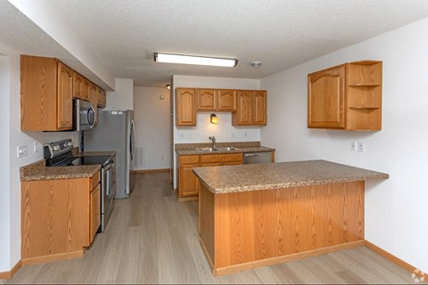 A kitchen with wooden cabinets and a granite counter top.
