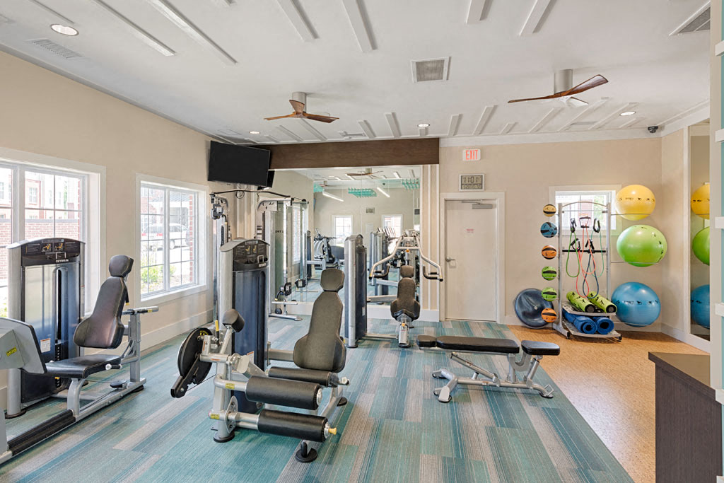 Fitness center with strength-training equipment; yoga area